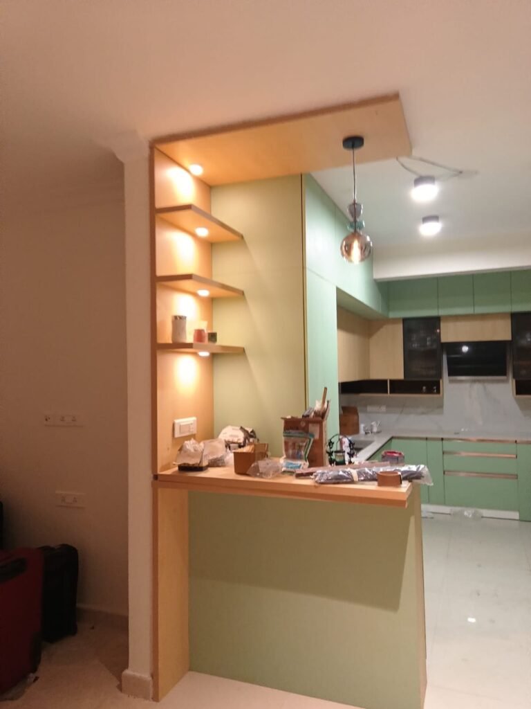 Kitchen with lit wooden display shelves and a breakfast counter