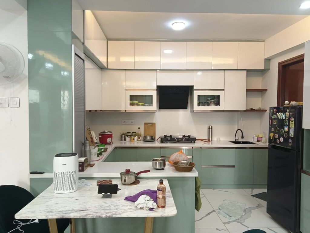 L-shaped modular kitchen with a marble-top breakfast counter