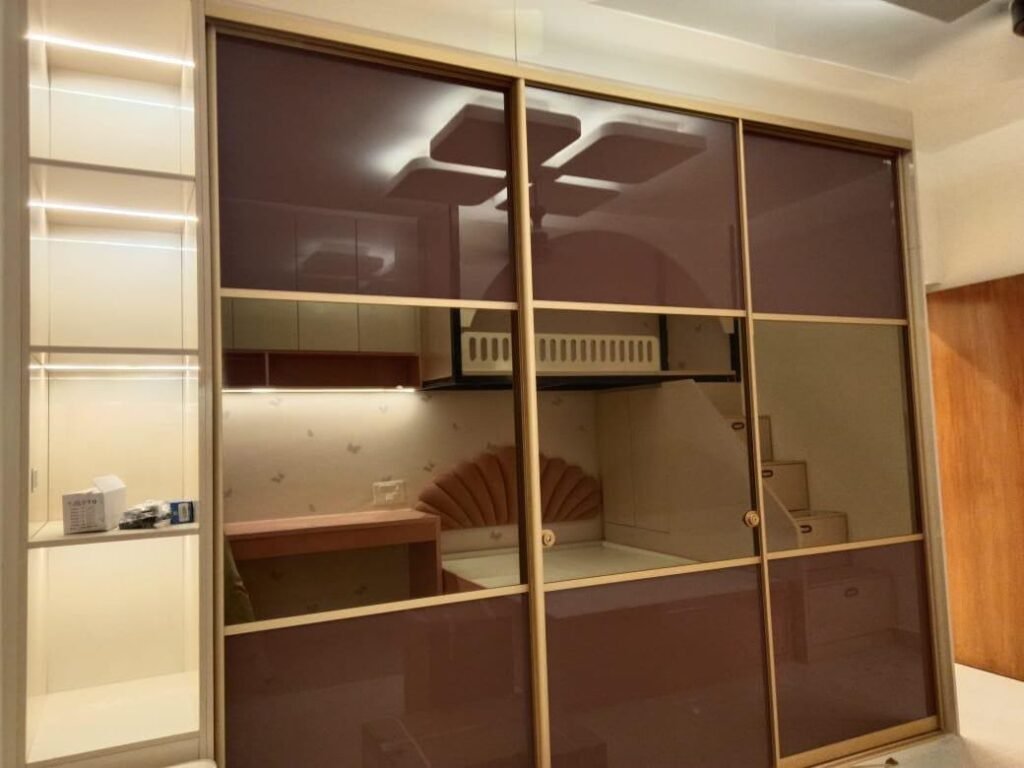 Sliding wardrobe with tinted glass panels and inner lighting